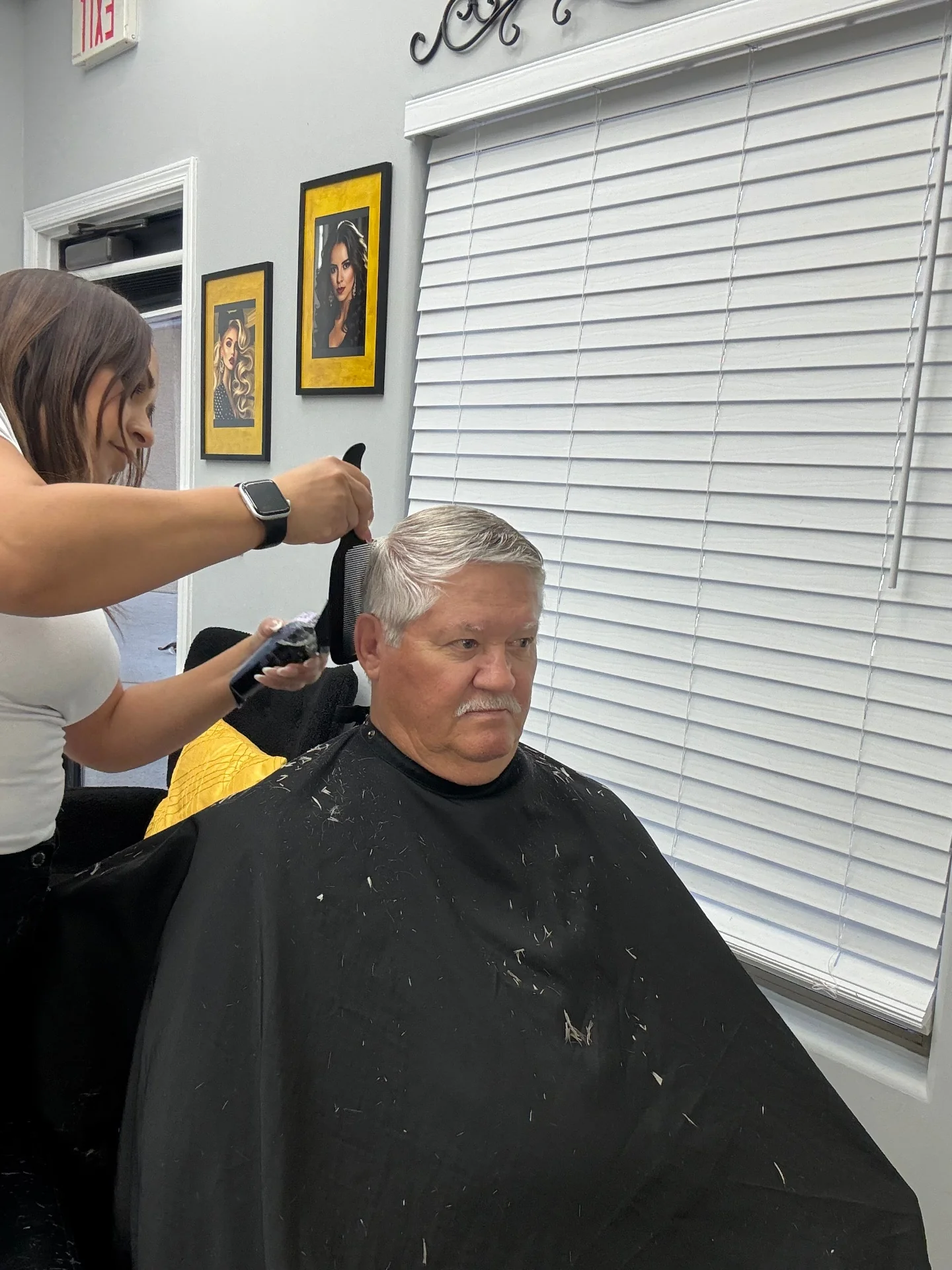Comb-and-clipper finishing pass on the back and side of a senior haircut by Hair Ambition mobile barber in Goodyear, AZ