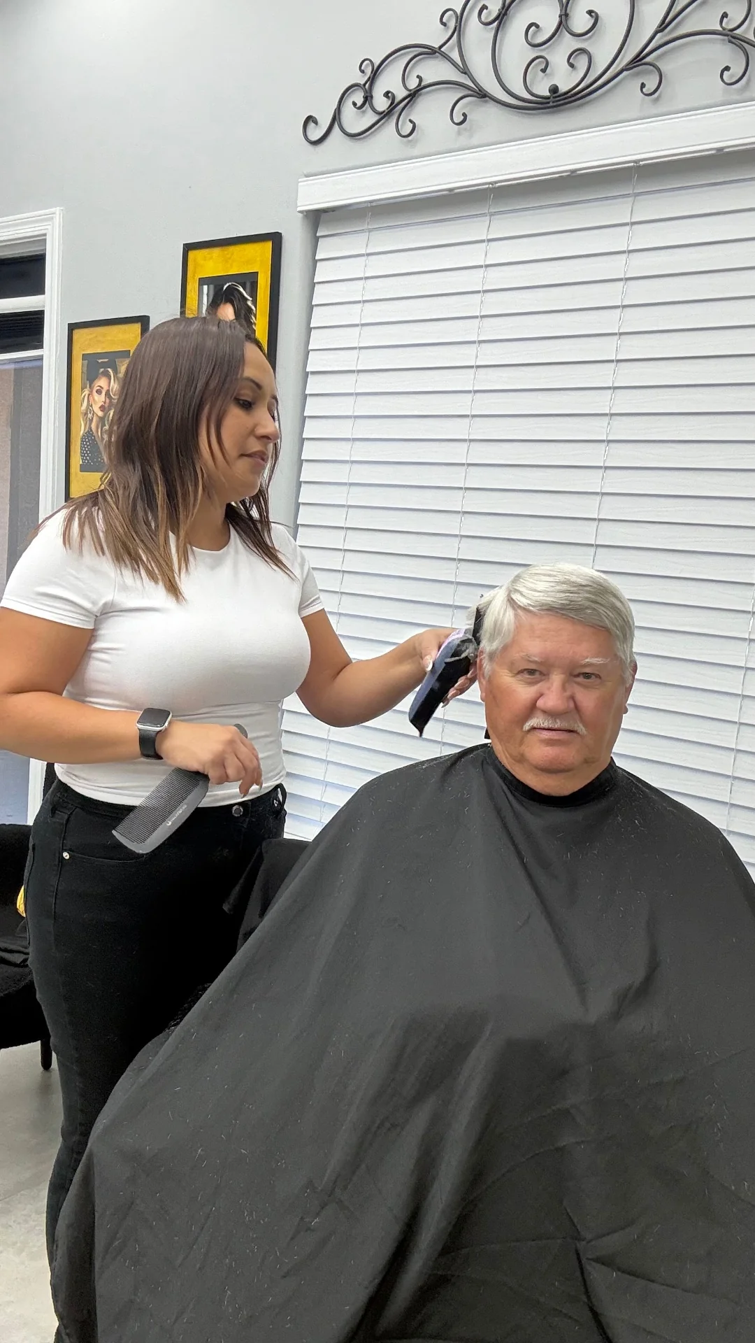 Stylist shaping the side of a senior client's haircut during a home visit from Hair Ambition mobile barber in Goodyear, AZ